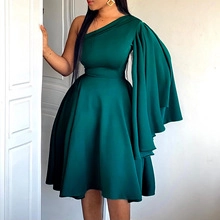 Detail of elegant dark green one-shoulder dress with multi-layer ruffled sleeves