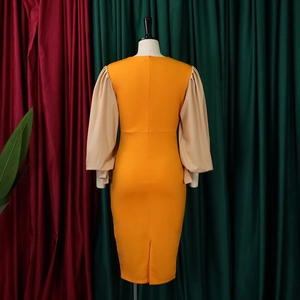 Rear view of bodycon dress with orange bodice, beige lantern sleeves and back slit detail