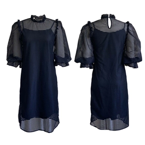Detail view of navy hollow-out mesh dress with puff sleeves and back button closure