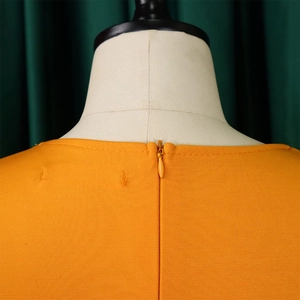 Detailed macro view of the bright orange dress featuring a seamless invisible back zipper