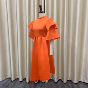 Detail of elegant orange dress showing double-layered ruffle sleeves and high-neckline