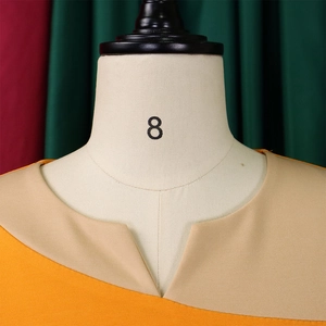 Detail of V-neckline with yellow and beige color-block design on textured dress