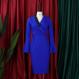 Detail of royal blue V-neck dress featuring floral embroidery and elegant flare sleeves
