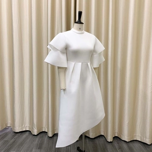 Detail view of white high neck dress with double ruffles and asymmetrical hemline