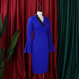 Detail view of royal blue dress showing V-neckline with black 3D floral appliques and pearls