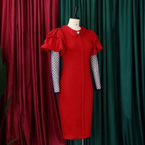 Detail of layered mesh sleeves with polka dots and white buttons on a red dress