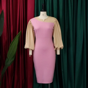 Detail view of contrast puff sleeves and V-neckline on a slim-fit patchwork midi dress