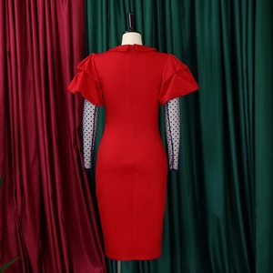Detail of red bodycon dress featuring sheer black polka dot mesh sleeves and collar design