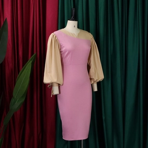 Detail of pink and beige dress featuring unique asymmetric neckline and puffed tie sleeves