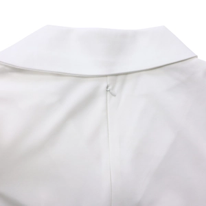 Détail d'une robe blanche montrant le col en V et la fermeture éclair invisible de qualité