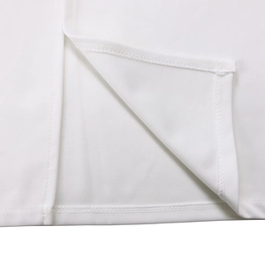 Détail de l'ourlet de robe blanche avec fente latérale et finition à double piqûre nette