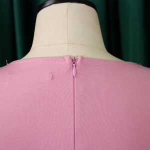 Detailed view of the back invisible zipper and collar on a pink plus size dress