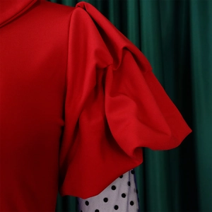 Close-up of red puffed sleeves with elegant black and white polka dot mesh detail