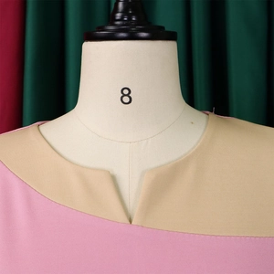 Detail of V-neckline with pink and beige patchwork design on textured knitted fabric