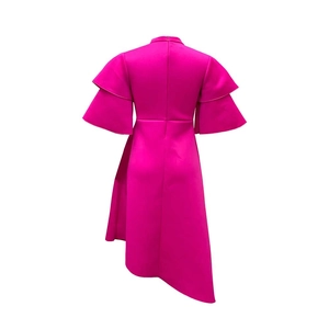 Detail view of fuchsia evening dress featuring layered ruffle sleeves and asymmetrical hemline