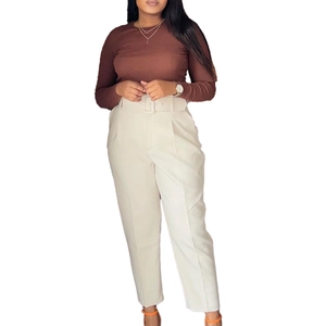 Close-up of high-waisted white dress pants featuring a matching belt and sharp front pleats