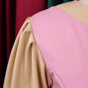 Detail of color-block dress shoulder with pink fabric and khaki puff sleeves