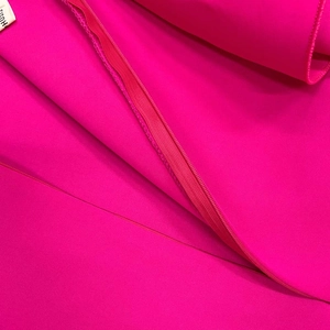 Macro detail of rose pink dress fabric showing stitching and invisible zipper closure