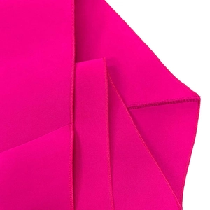 Detail of high-quality stitching on the hem of a vibrant magenta evening gown fabric