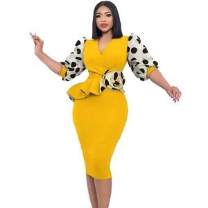 Détail d'une robe crayon jaune avec manches bouffantes en mesh à pois et rose à la taille