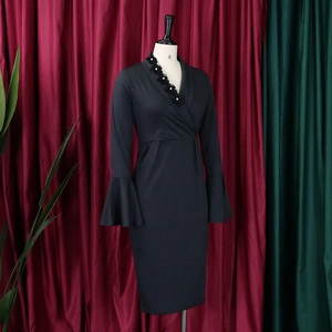 Close-up of elegant V-neckline featuring black lace trim and white pearl accents on dress