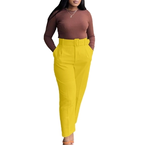 Detail of high waisted yellow trousers with matching wide square buckle belt detail