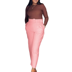 Women's brown long sleeve knit top with pink high waist straight suit trousers and belt