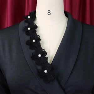 Detailed view of handmade black lace flowers and pearls on the dress collar