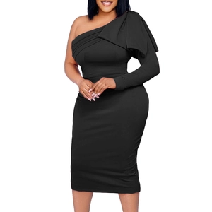 Détail d'une robe noire asymétrique avec un grand nœud décoratif sur la manche longue