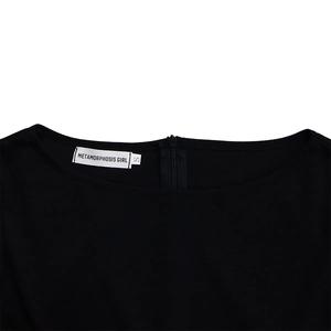 Detail view of dress neckline with invisible zipper and Metamorphosis Girl brand label