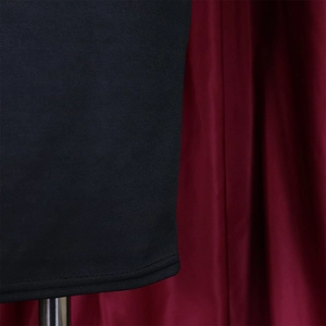 Detail view of the fine knit texture and double-stitched hem on the black V-neck dress