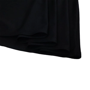 Detail of multi-layered pleated black dress hem featuring fine stitching and flowing fabric