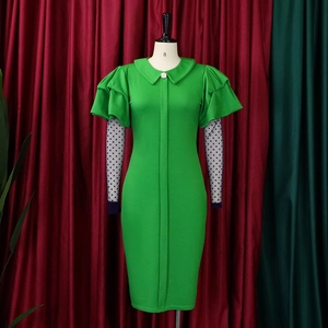 Detail of green fitted dress featuring mesh polka dot sleeves and ruffled tiered design
