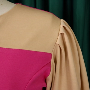 Detail of color-block dress showing puff sleeves and pink beige fabric textures