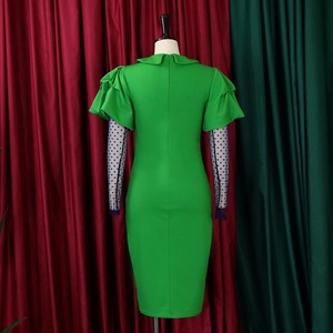 Detail of green ruched bodycon dress featuring black polka dot sheer mesh sleeves