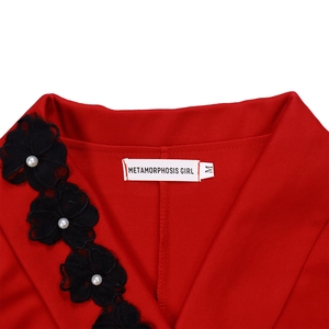 Detail of red V-neck dress featuring black lace flowers and pearl beads embellishment