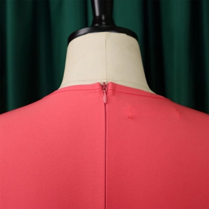 Dettaglio dell'abito rosa corallo con scollo rotondo e chiusura a zip invisibile dietro