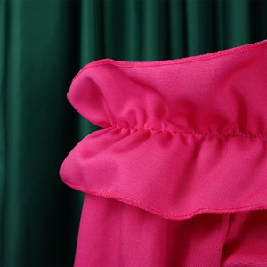 Détail de la taille élastique à volants sur une robe rose avec texture tricotée