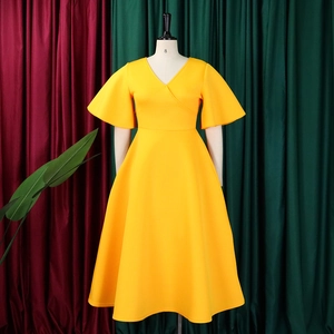 Detailed view of the bright yellow V-neck flared sleeve dress on a studio mannequin