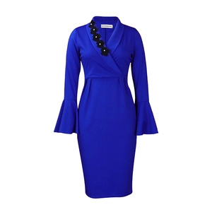 Detail of royal blue V-neck dress featuring a black floral brooch and pearl accents