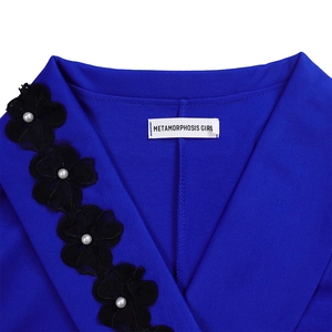 Detail of royal blue V-neck with black floral lace edging and white pearl accents