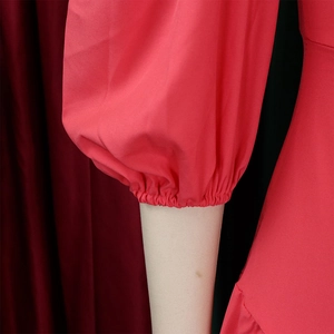 Dettaglio dei polsini a lanterna rossi con finitura elastica su un abito di moda