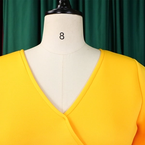 Detail view of a bright yellow dress with a stylish V-neck design on a mannequin model