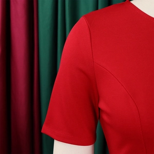 Detailaufnahme des roten Kurzarmkleides mit Stoffstruktur und hochwertigen Nähten
