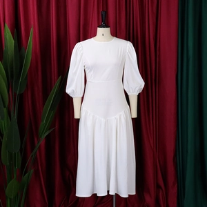 Dettaglio dell'abito bianco con maniche a sbuffo e elegante design a vita pieghettata