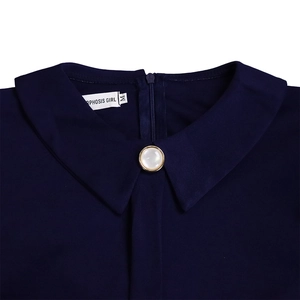 Detail of navy blue dress neckline with pearl button and brand label macro view