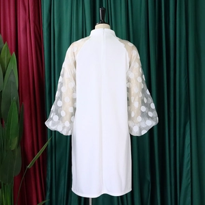 Detail eines modernen weißen Qipao-Kleides mit transparenten Polka-Dot-Puffärmeln