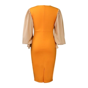Detail of slim fit two-tone dress with orange body and beige lantern sleeves