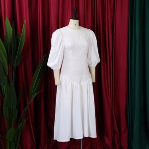 Dettaglio dell'abito bianco con maniche a sbuffo, scollo rotondo e vita stretta elegante