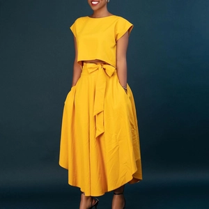 Detail of yellow two-piece set featuring short sleeve crop top and high waist maxi skirt